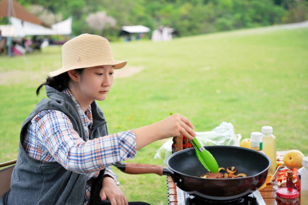 A woman is cooking outdoors.