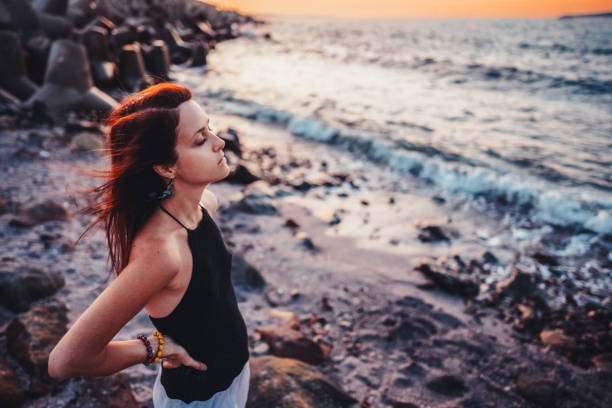 istock Woman at the seashore staring the sunset 2150699007