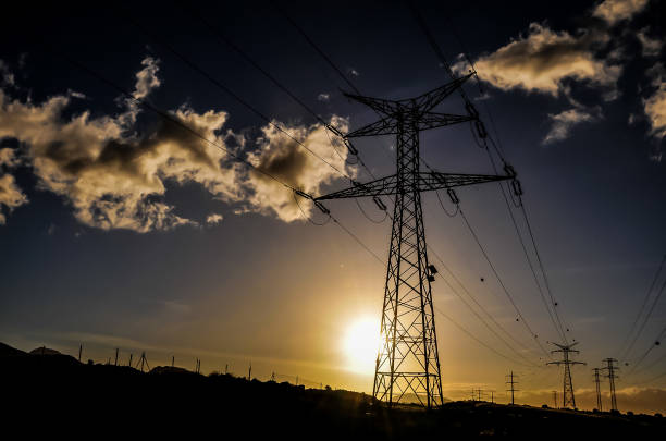 istock A power line tower is silhouetted against a cloudy sky 2150699099