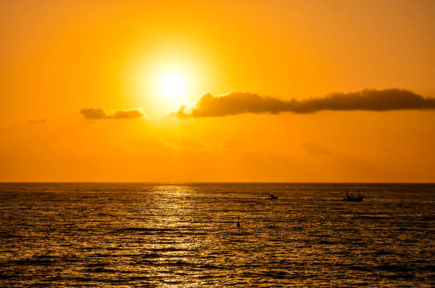 istock The sun is setting over the ocean, casting a warm glow on the water 2150699189