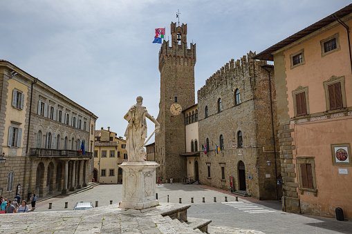 Arezzo, Tuscany. May, 2022: cityscape. Piazza del Duomo with historical buildings and Ferdinando de Medici statue, by Pietro Francavilla, Santi Pietro e Donato Cathedral in Arezzo, Tuscany, Italy.