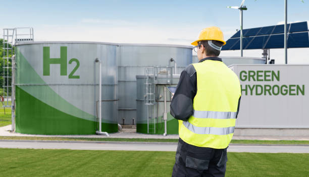 Engineer with tablet computer on a background of Green Hydrogen factory.
