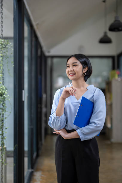 istock businesswoman holding a pen and document clipboard 2150704246