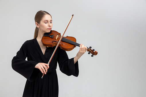 Happy teenage girl enjoying playing violin