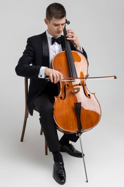 istock Passionate cello player sitting on chair performing concert 2150704996