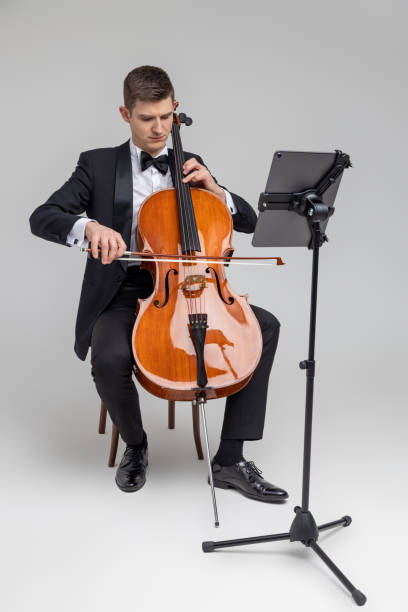 istock Man artist wearing tuxedo playing cello with music note 2150705028