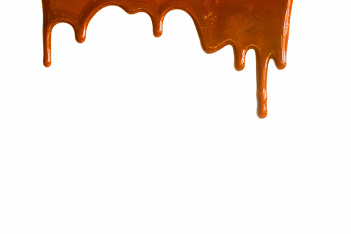 Dripping sweet caramel sauce texture on a white background, food texture background.