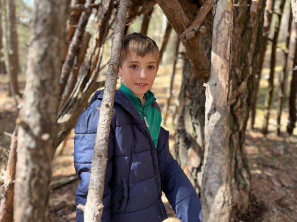 istock child building a hut in the forest with tree branches. 2150708244