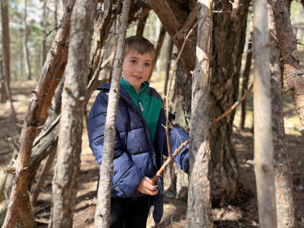 istock child building a hut in the forest with tree branches. 2150708259