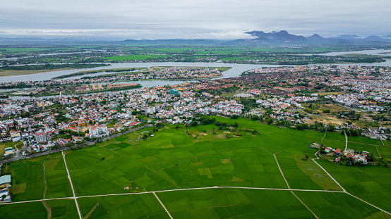 High angle view of rice fields with village near Hoi An, Vietnam in the background