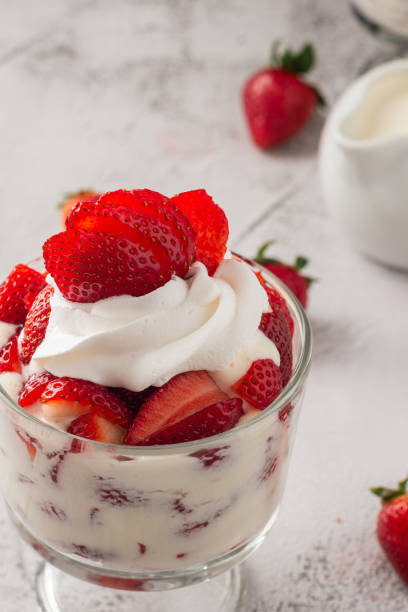 istock Strawberries with cream in a glass cup on cement table. Copy space. 2150710846