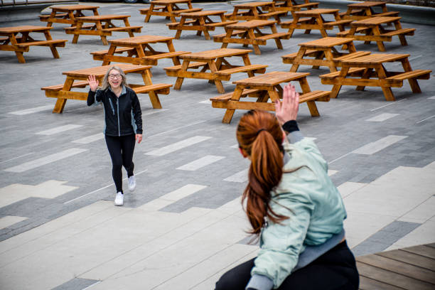 fitness and friendship as these Vietnamese women come together for a workout session amidst the urban landscape, their energy and enthusiasm radiating as they greet each other with a friendly wave.