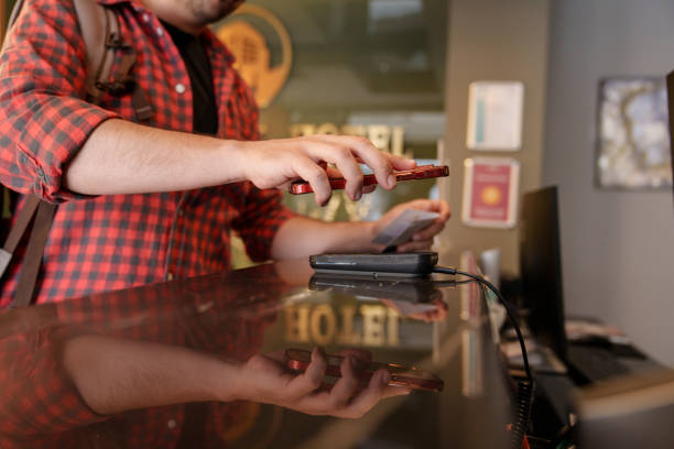 istock Close up to man mobile paying at the hotel reception. 2150715082