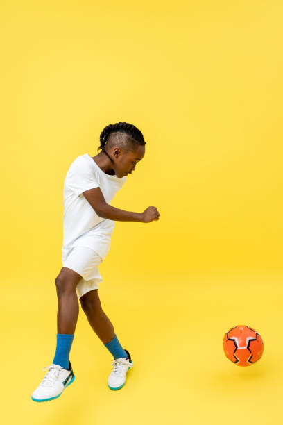 istock Sportive little mixed-race boy doing tricks with soccer ball 2150717417