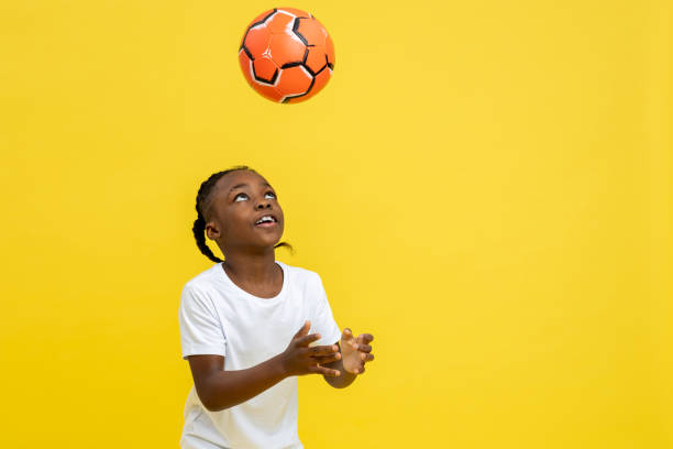 Mixed-race little boy having football workout with ball