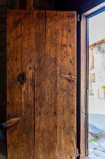 Wooden door with the very marked grain on an open church with a beautiful bright day outside in spring