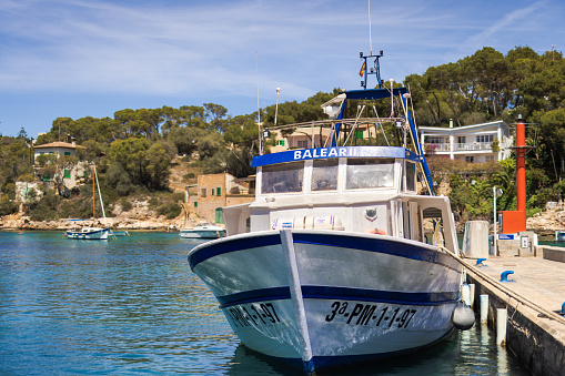 Cala Figuera, Spain -April 20, 2024: Cala Figuera's fishing harbor, highlighting a large boat. Located in a small, scenic bay, this charming harbor is well-loved by tourists visiting southeastern Mallorca.