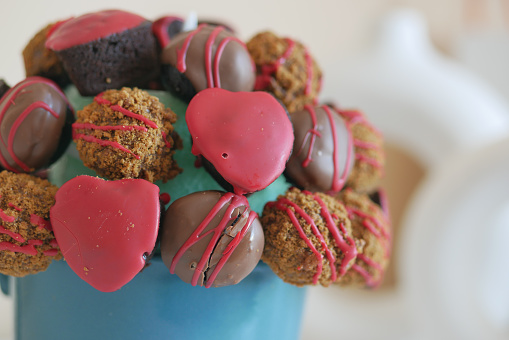A blue bucket filled with chocolates and hearts, a sweet confectionery delight.