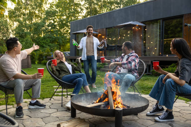 istock Cheerful multicultural friends sitting near fire on backyard enjoying happy weekend 2150723388