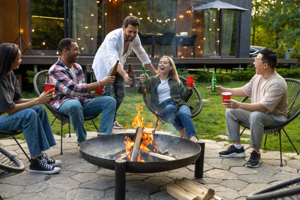 istock Cheerful multicultural friends sitting near fire on backyard enjoying happy weekend 2150723394