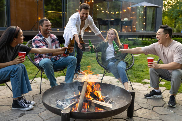 istock Cheerful multicultural friends sitting near fire on backyard enjoying happy weekend 2150723397