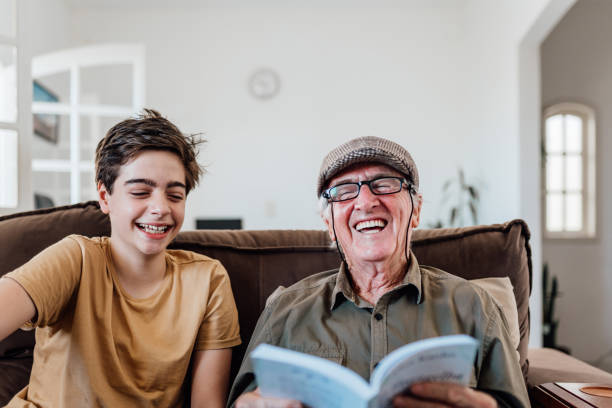 istock Grandson and grandpa having fun reading a book 2150724806