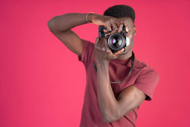 istock A man wearing a red shirt is taking a picture with a camera 2150729704