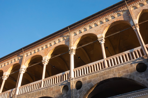 Medieval arches of historic building palazzo della ragione near piazza dei frutti in Padova, Italy with diagonal composition in evening with blue sky