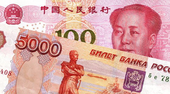 Russian roubles and Chinese yuan banknote with Mao Zedong portrait. Business concept of the exchange rate, stock exchange, trading and cooperation