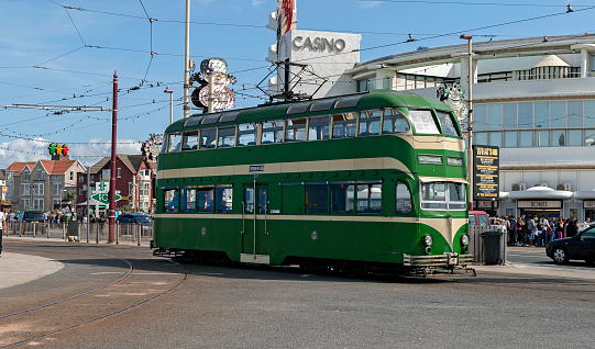 View of a tram in the centre of Blackpool, UK.  People can be seen on the promenade.