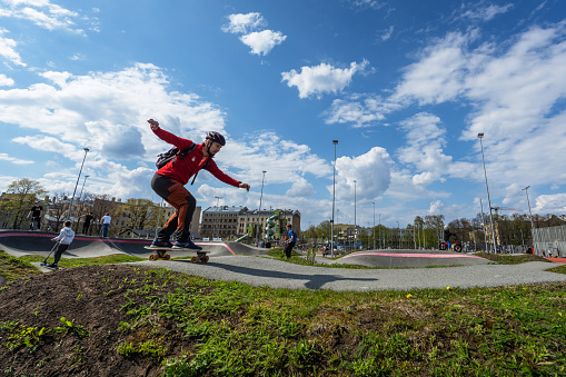Riga, Latvia - April 27, 2024: Young people have fun in the skatepark of the center sports quarter