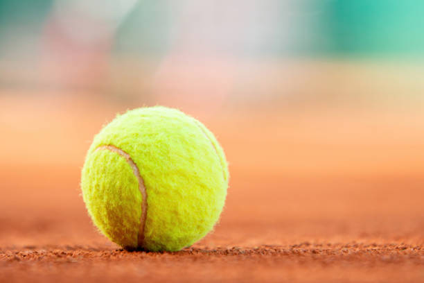 istock Tennis ball on clay court with copy space 2150738334