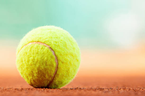 istock Tennis ball on clay court with copy space 2150738347