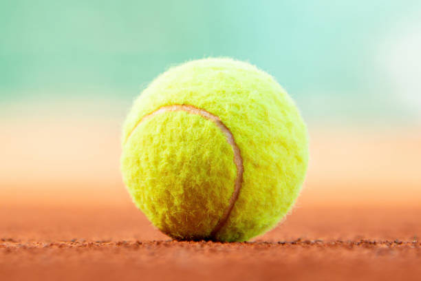 istock Tennis ball on clay court with copy space 2150738411