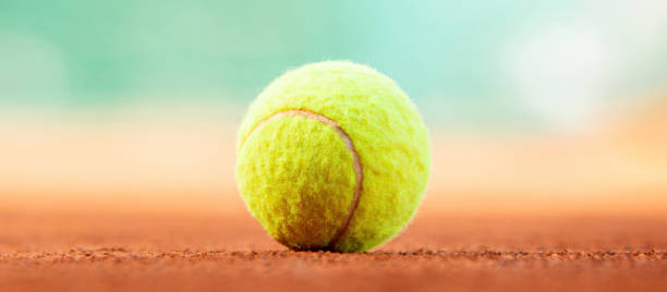 istock Tennis ball on clay court with copy space (8k wide image) 2150738412