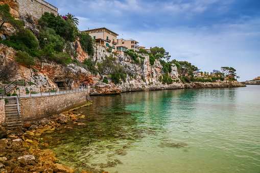 The coastline of Porto Cristo, Mallorca, showcasing crystal-clear turquoise waters against a rocky landscape