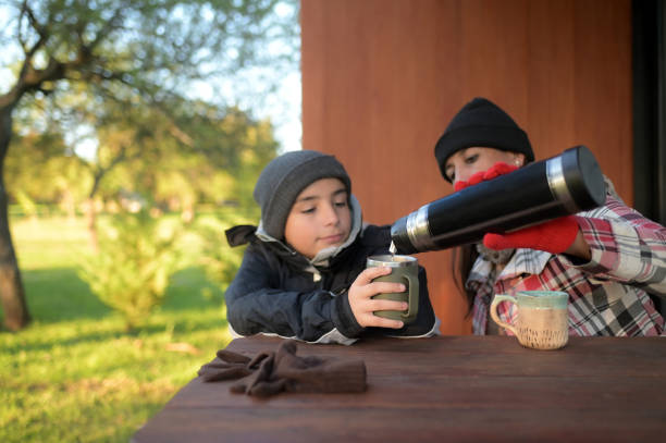 woman and child outdoors drinking coffee