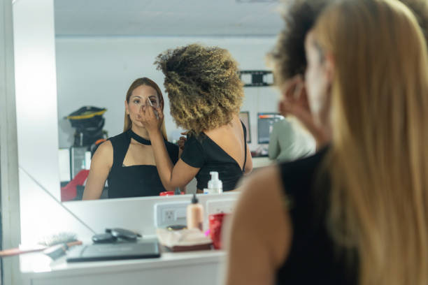 istock Professional makeup artist serves her client inside her beauty salon 2150739467