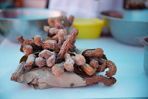 Churros, a very popular sugary bread, sitting on a counter at a market stall
