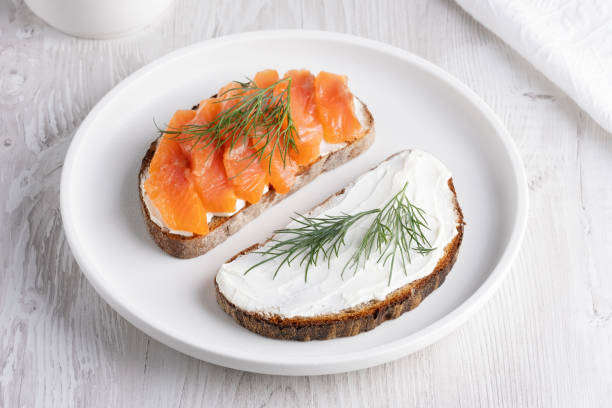 istock Rye sandwich with salmon and cream cheese on white wooden table 2150741509