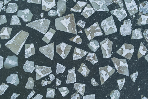 Photo background texture of ice floes floating in the Baltic Sea, photo from a drone looking down. High quality photo