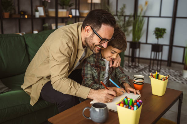 istock Father and son draw and paint together at home leisure activity 2150745394