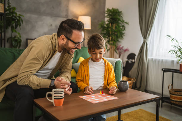 istock Father and son play board game together at home 2150746278