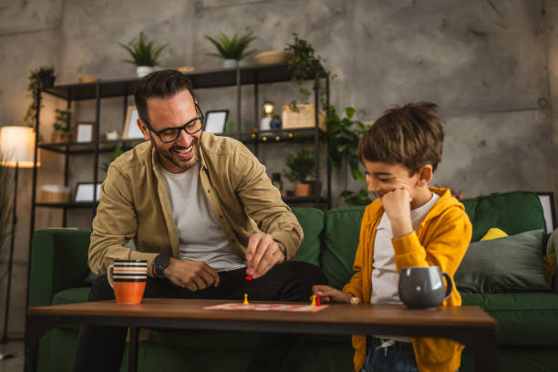 istock Father and son play board game together at home 2150746282