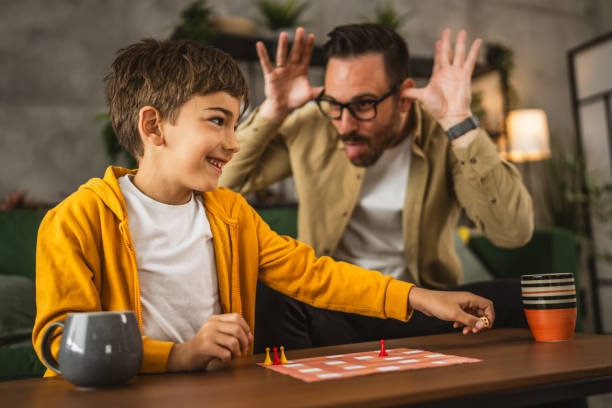 istock Father and son play board game together at home 2150746398