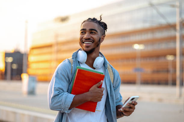 istock Hispanic male student waiting for a train and checking smart phone 2150746450