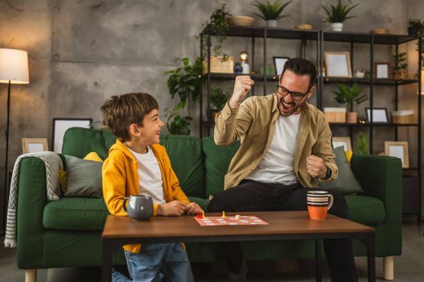istock Father and son play board game together at home 2150746515