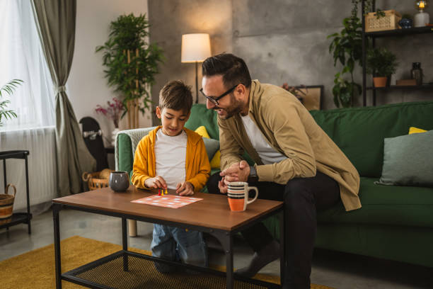 istock Father and son play board game together at home 2150746516