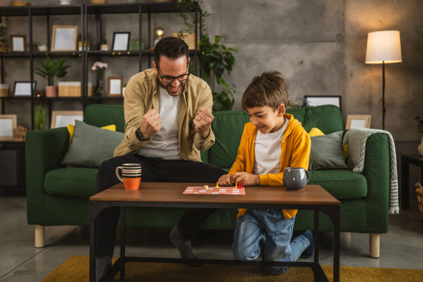 istock Father and son play board game together at home 2150746593