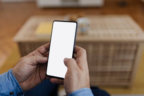 istock Male tech user relaxing on sofa holding smartphone mock up blank white screen 2150746676